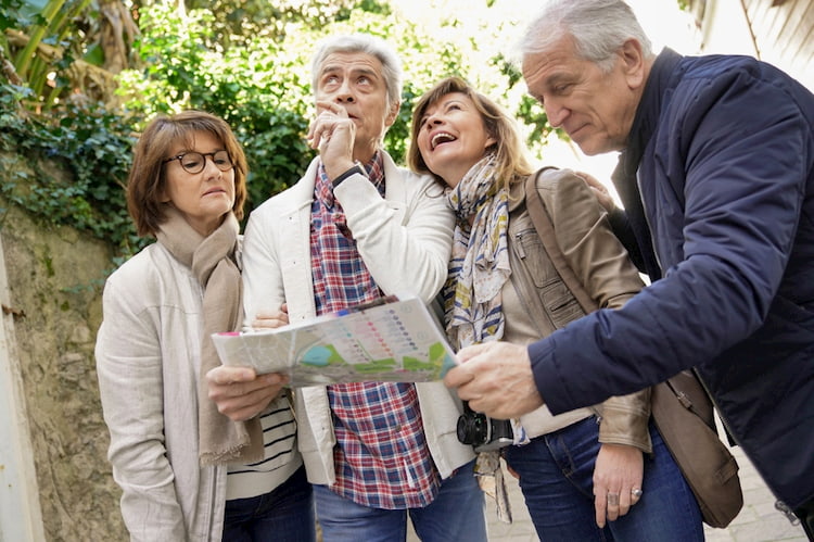 a group of senior citizens consult a map as they walk around New York City